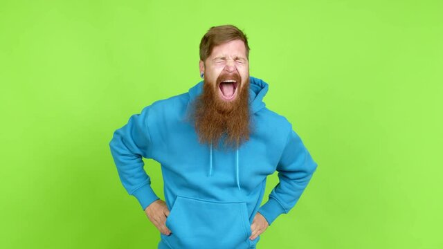 Redhead man with long beard keeping the arms crossed while smiling over isolated background