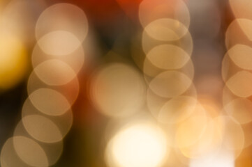 Blurred background with round bokeh in golden color. Selective focus. Bright bokeh in pattern. Bright ligts. Abstract blurred background.
