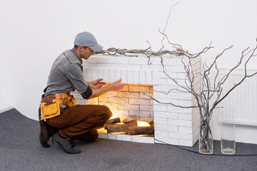 Fireplace installing in white brick wall