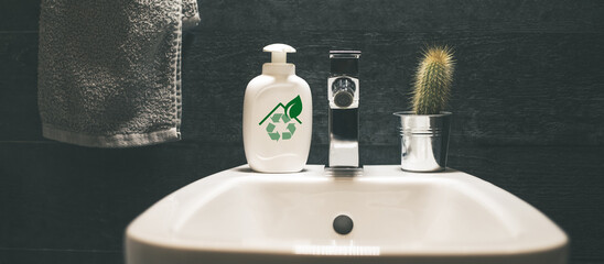 Closeup view of a bidet with towel, soap dispenser and a cactus. Modern environment bathroom...