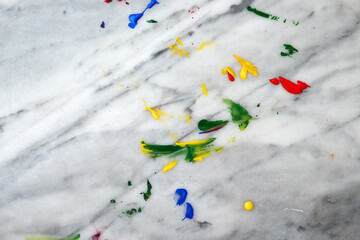 The beautiful primary colors of red, blue, green and yellow with paint brushes on a smeared marble table after preparing a christmas holiday project for children