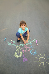 Fototapeta premium The child draws a family on the asf. Selective focus.