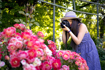 Young woman taking photos with a professional camera at park during vacations