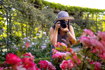 Young woman taking photos with a professional camera at park during vacations