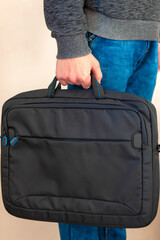 close-up. bag in hand, guy holds a laptop bag in his hands, a protective folder for a laptop.