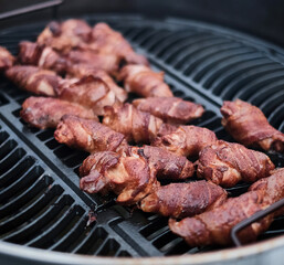 Bacon wrapped chicken wings on the grill, close up