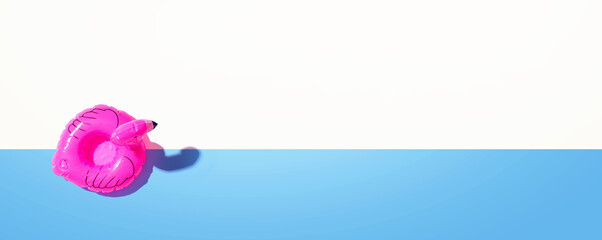 Summer concept with a pink flamingo float - flat lay