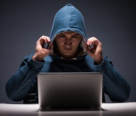 Computer hacker working in dark room