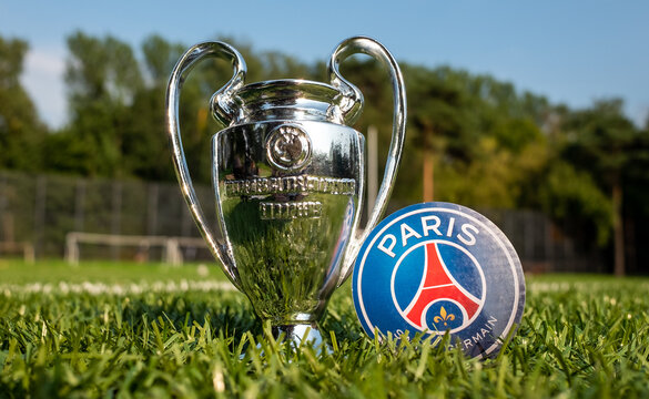 August 27, 2021, Paris, France. The emblem of the football club Paris Saint-Germain F.C. and the UEFA Champions League Cup on a green turf.