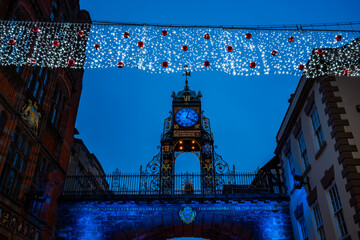 Eastgate clock tower and Christmas lights decorating Chester's old town, the Rows, UK