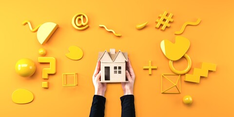 Person holding a cardboard house with geometric shapes from above