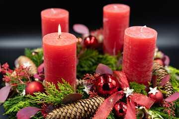 Low angle view of beautiful advent wreath with one burning candle on black background - obrazy, fototapety, plakaty