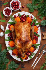 Christmas roasted duck with persimmon, pomegranate and cranberries. A festive dish. Top view