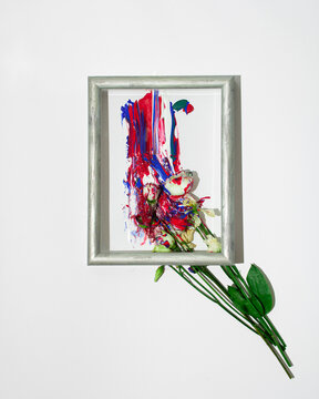 Creative spring concept made. Bouquet of flowers as paint brush and colorful roses on white background. Minimal nature flat lay in gray frame.