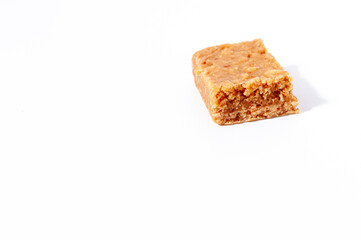 Traditional Brazilian peanut-based candy called "paçoca" isolated on a white table or background.
