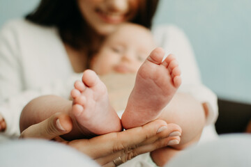 Health Insurance For Newborn Babies. Life Insurance for New Baby. Mother holding in hands feet of newborn baby. Baby feet in parent hands