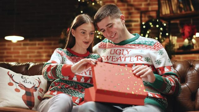 Christmas gift woman opening present with surprise sexy underwear laughing enjoying funny joke with boyfriend celebrating festive holiday at home. Slow motion in 4k.
