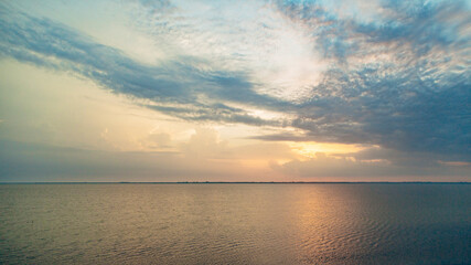 Beautiful Landscape of the Sunset on the Beach. Calm Weather with Blue Clouds in the Blue Sky Reflected in the Water