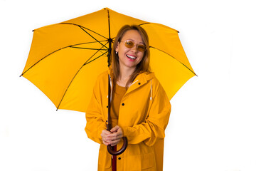 Smiling girl in yellow raincoat stands under umbrella isolated on white background