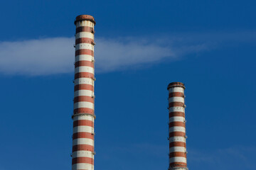 Smokestacks of power plant in Italy, Tuscany with cloudy sky