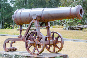 Antique Iron cannon on the green grass at a public park.