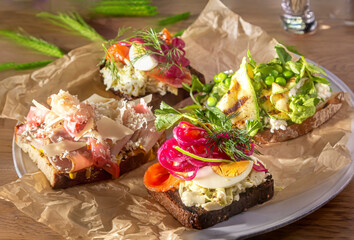 Traditional Danish sandwiches, Smorrebrod with salted salmon, pickled onions, vegetables, green peas and bacon