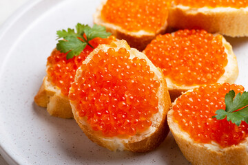 Naklejka na ściany i meble Delicious Sandwiches with red caviar on a white plate background