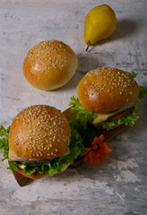 Homemade burgers with orange flower. Winter. Gray background.