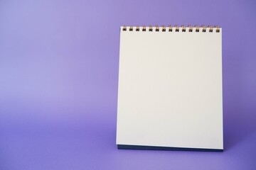 A paper white calendar stands on the table. Mock Up Vector Template. Blank Calendar on purple background.