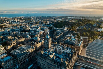 Obraz premium Aerial view of Edinburgh as the sun rises over the city. Early morning mist creeps along the shoreline of the North Sea like steam rising from a mug of freshly brewed coffee