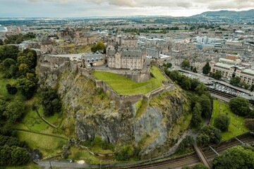 Aerial view of Edinburgh Castle, a royal castle occupying a commanding position atop a volcanic crag with cliffs on three sides and the fourth side facing the capital city of Edinburgh