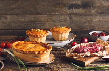 Tasty beef pot pies with meat on table