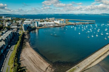 Fototapeta na wymiar Iconic marina, located along the east coast of Scotland, presents a stunning view of the sea. Aerial view of the marina, displays a stunning image of the marina filled with large yachts and boats