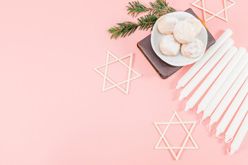 Powdered donuts in saucers, bible, nine white candles and three wooden stars of David on the right.