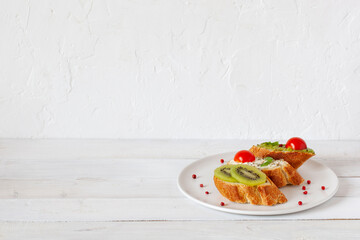 Three mini sandwiches on a plate on wooden background