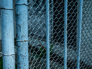 The blue iron fence is faded because it's old
