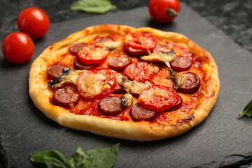 Slate plate with delicious mini pizza on table, closeup