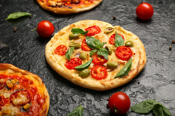 Delicious mini pizzas on dark background, closeup