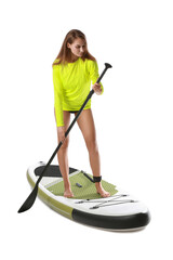Sporty young woman with board for sup surfing and oar on white background