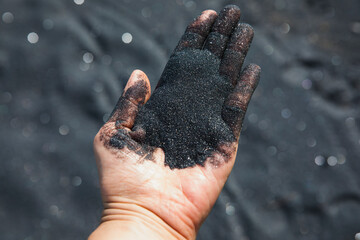 Volcanic sand falling from hand, close-up