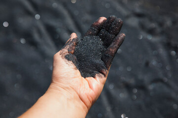 Volcanic sand falling from hand, close-up