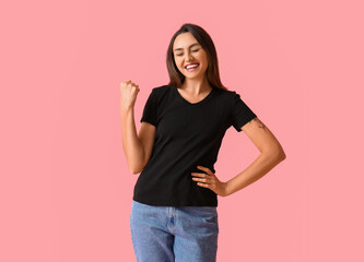 Happy young woman in blank t-shirt on color background