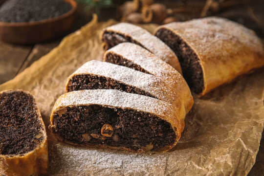 Pieces of tasty poppy seed strudel on wooden background