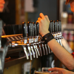 Fototapeta na wymiar the bartender pours beer in the beer bar