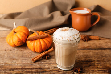 Glass of tasty pumpkin latte on table