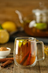 Glass cup of tasty fruit tea with cinnamon on table