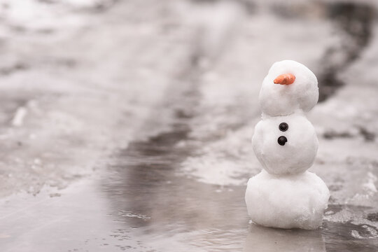 the concept of the arrival of spring. the snowman melt, stands in melted snow, ice and water. copy space
