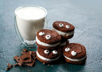 Funny chocolate cookies with milk on dark background