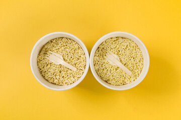 Instant Ramen Noodles in Cup with fork on yellow background