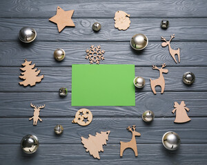 Blank green card and Christmas decor on dark wooden background